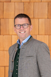 Mann in Tracht vor Holzfassade, regionale Landwirtschaft Lungau, nachhaltige Spezialitäten